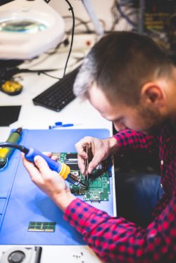 IT engineer technician repairing computer component in electronics service and maintenance shop